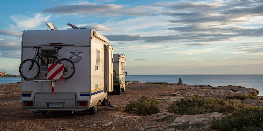 Two caravans parked on a cliffside overlooking the ocean