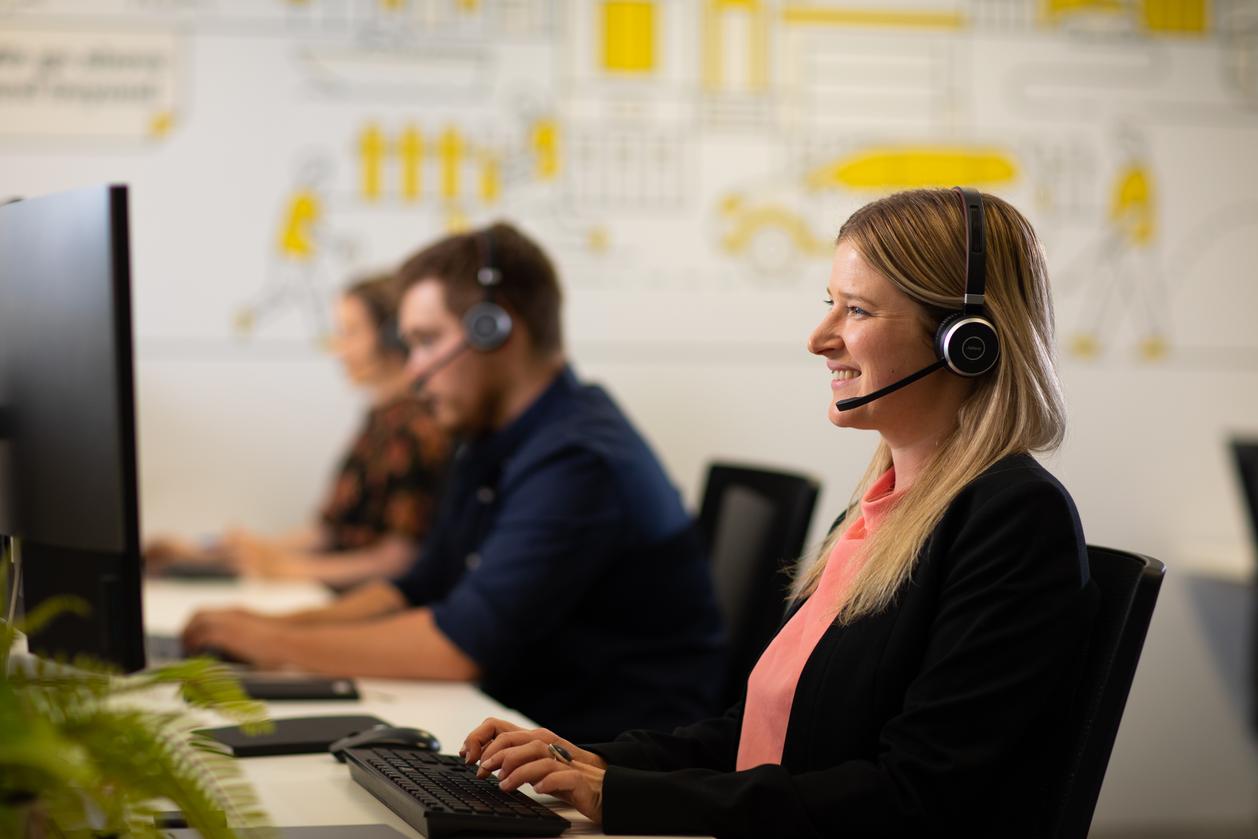 woman in front of a computer wearing a headset